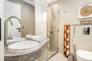 Ein modernes Badezimmer mit zwei Waschbecken, einer Dusche und einer Toilette.