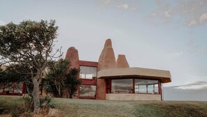 A modern house with a unique architectural design, featuring large windows and a flat roof.