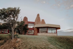 A modern house with a unique architectural design, featuring large windows and a flat roof.