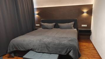 Ein Schlafzimmer mit einem Bett, einer Bank und zwei Wandleuchten.