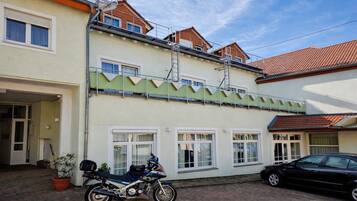 A two-story building with a motorcycle parked in the driveway.