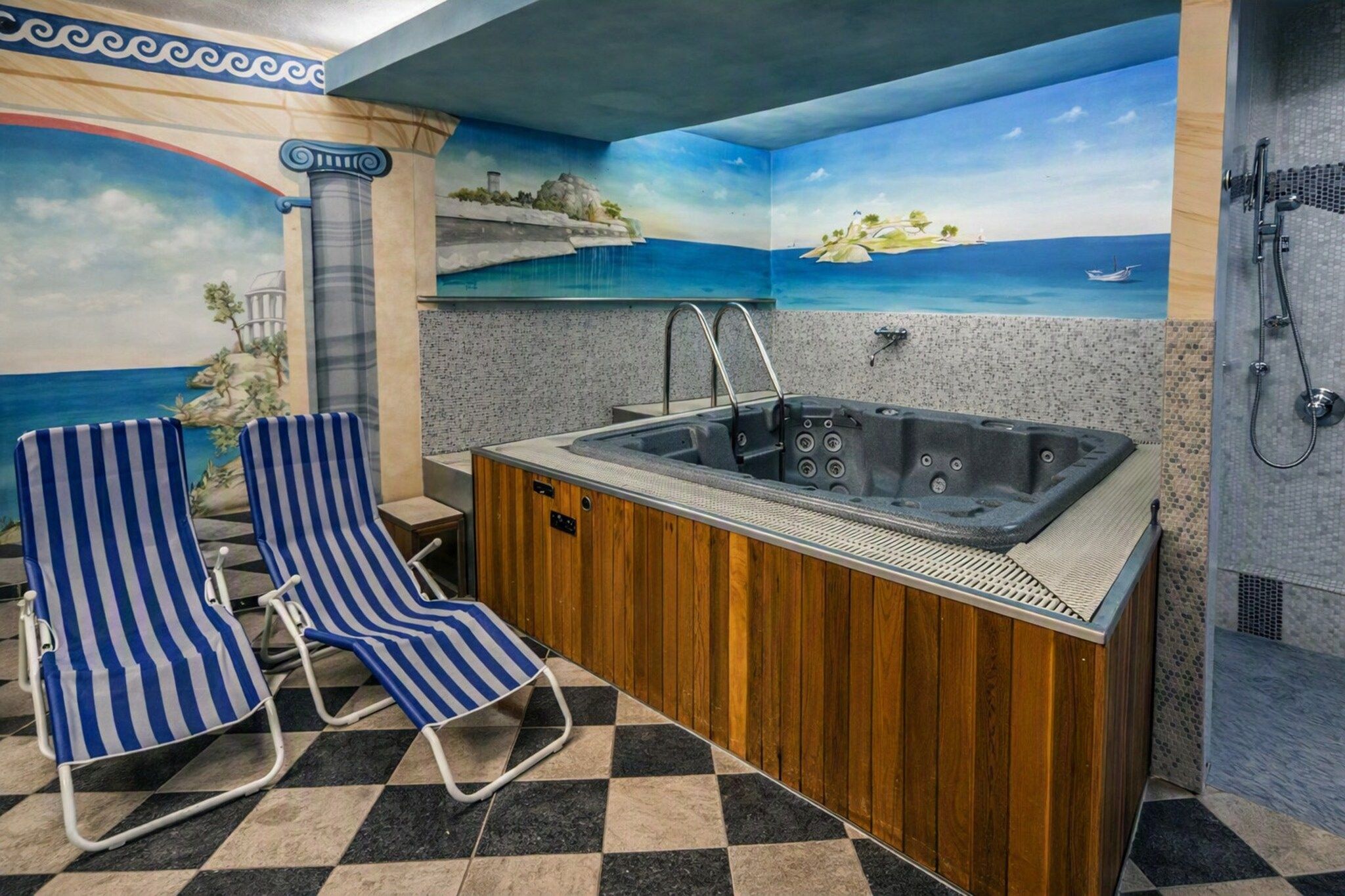 Ein Badezimmer mit einer Badewanne, einer Dusche und einer Sitzecke mit gestreiften Stühlen.
