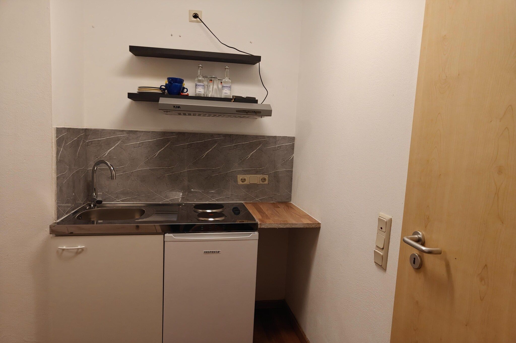 Een praktische keuken met een ingebouwde vaatwasser, een spoelbak en een fornuis.