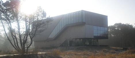 A modern building with a unique architectural design, featuring a prominent staircase and large glass windows.