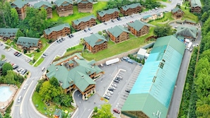 Eine Lodge mit mehreren Blockhütten, einem großen Parkplatz und einem Schwimmbad.