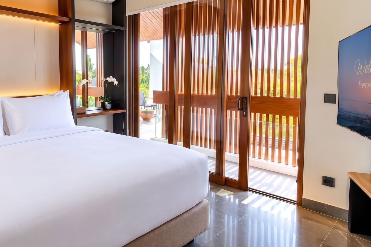 A modern hotel room with a large bed, a TV, and a balcony with wooden blinds.