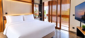 A modern hotel room with a large bed, a TV, and a balcony with wooden blinds. - Elysera Villa Nyanyi (Tabanan)