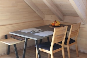 A dining area with a table, chairs, and a fruit bowl. - Holiday apartment Bernau Dorf (Bernau)