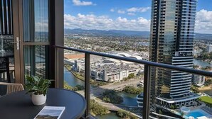 Un balcón con vistas a un paisaje urbano, que incluye un río y un puente.