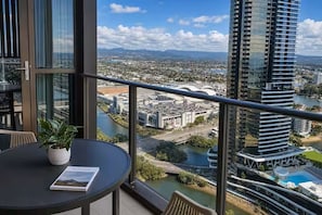 Ein Balkon mit Blick auf eine Stadtansicht, einschließlich eines Flusses und einer Brücke.
