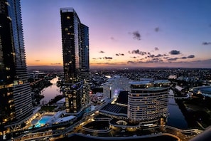 Ein Hochhaus-Hotel mit mehreren Etagen, Blick auf das Wasser und einer gut beleuchteten Stadtumgebung.