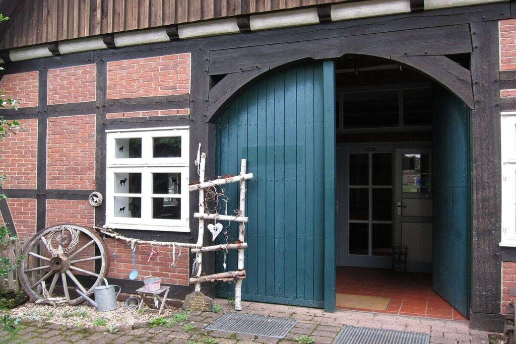 Un bâtiment traditionnel doté d’une grande roue en bois, d’une porte bleue et d’un mur en briques.