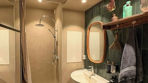 A bathroom with a shower, sink, toilet, and a mirror. - Light and spacious flat with balcony in Copenhagen (København S)
