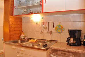 Eine Küche mit Herd, Spüle und Kaffeemaschine.