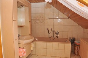 A bathroom with a bathtub, a toilet, and a shower. - Holiday apartment with 2 bedrooms (Egloffstein)