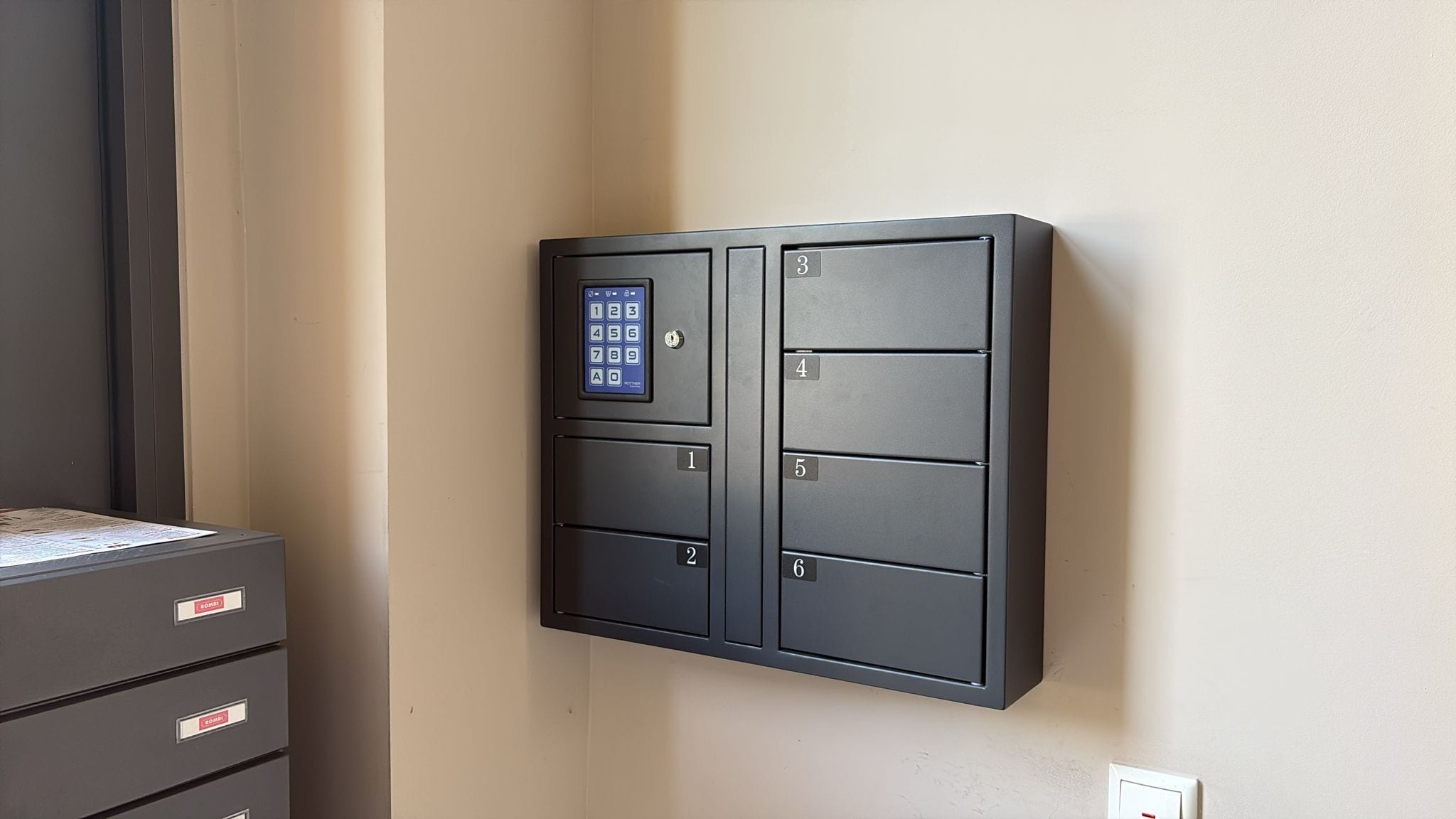 A wall-mounted security keypad with numbered compartments.