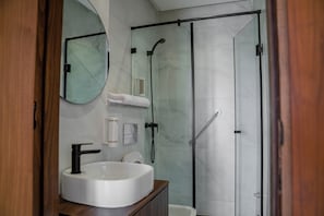 A modern bathroom with a glass-enclosed shower, a white sink, and a mirror. - HEAVEN BEACH IMMEUBLE 22 (Sidi Rahal Chatai)