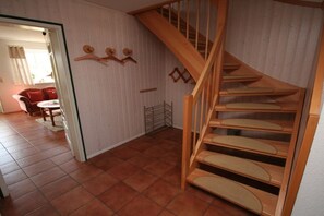 A staircase with wooden steps and a metal railing, leading to an upper floor. - Holiday apartment with 3 bedrooms (Tönning)