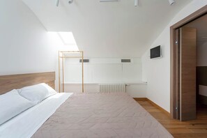 A bedroom with a bed, a radiator, a wooden wardrobe, and a skylight. - Stylish Milan loft in Darsena Area 3min to Metro (Milan)