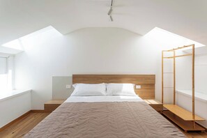 Una camera da letto con un letto, una testiera in legno e un lucernario.