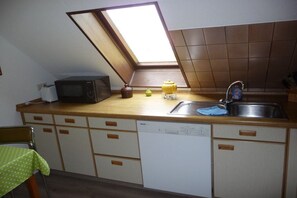 Una cocina con tragaluces, microondas, lavaplatos y lavamanos.