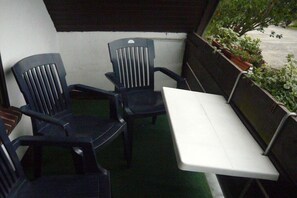 A balcony with a white table and two chairs. - Holiday apartment with 2 bedrooms (Sehestedt)