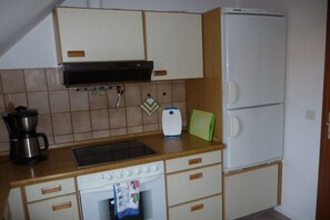 A compact kitchen with a stove, oven, and refrigerator. - Holiday apartment with 2 bedrooms (Sehestedt)