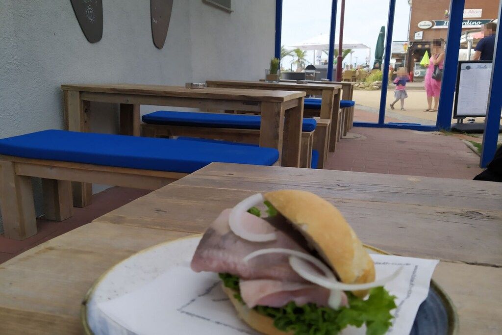 Ein Sandwich auf einem Tisch, im Hintergrund Bänke.