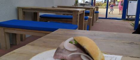 Ein Sandwich auf einem Tisch, im Hintergrund Bänke.