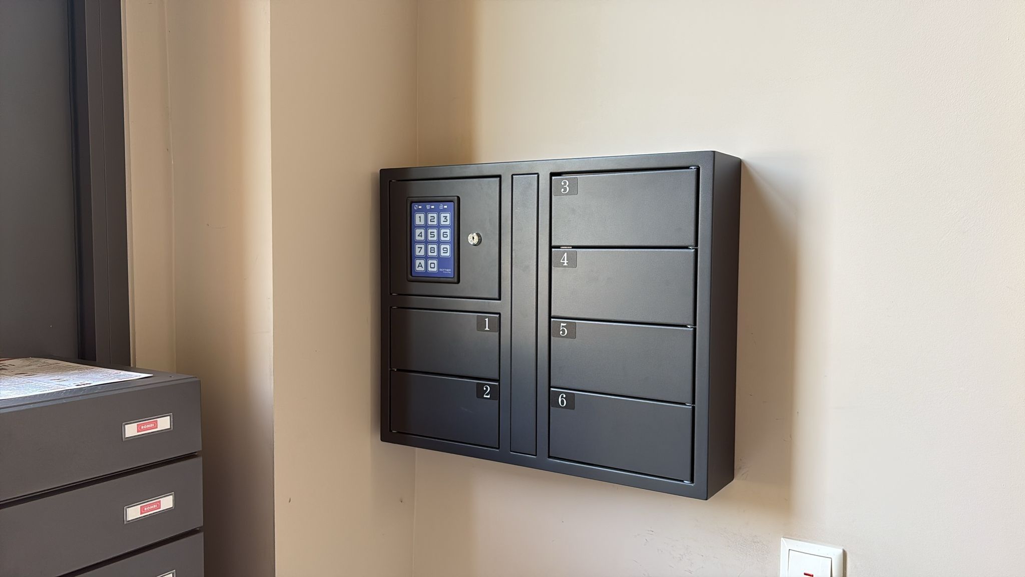 A wall-mounted security keypad with numbered compartments.