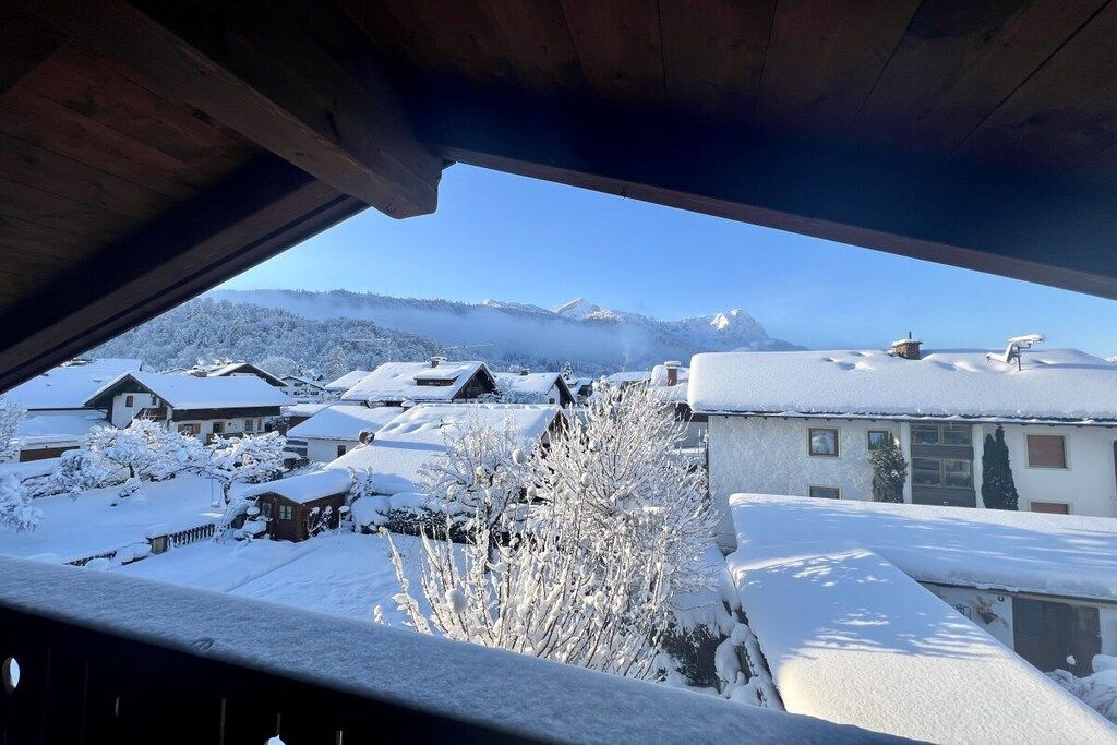 A snowy residential area with houses and a mountain in the background.