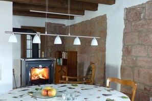 Ein gemütliches Zimmer mit Kamin, einem Tisch voller Früchte und einem Bücherregal.