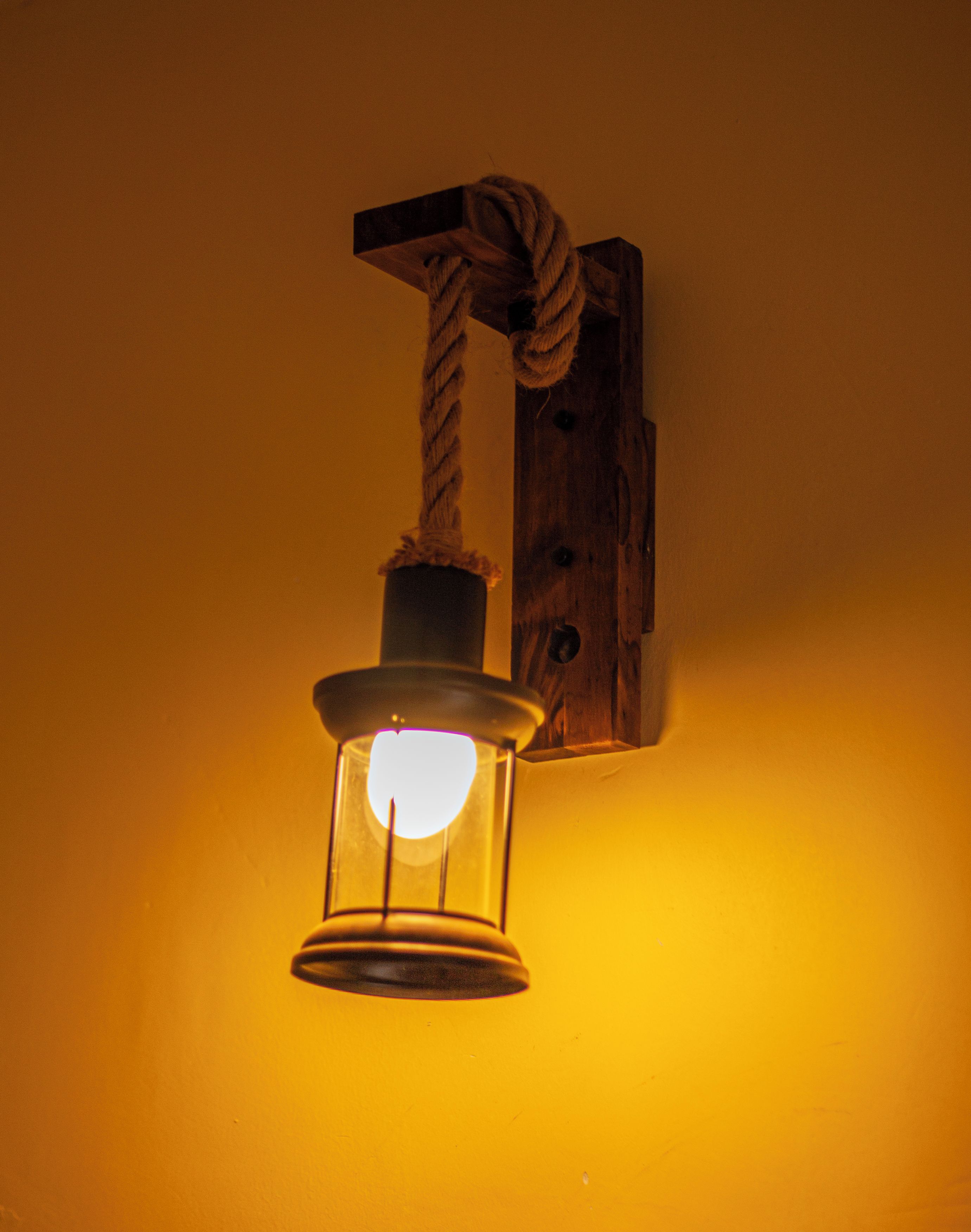 A wall-mounted light fixture with a rope decoration.