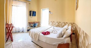 A hotel room with a bed, a desk, a chair, and a television. - Wenyeji Inn  Hotel (Moshi)