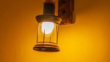 A wall-mounted light fixture with a rope and a cylindrical object.