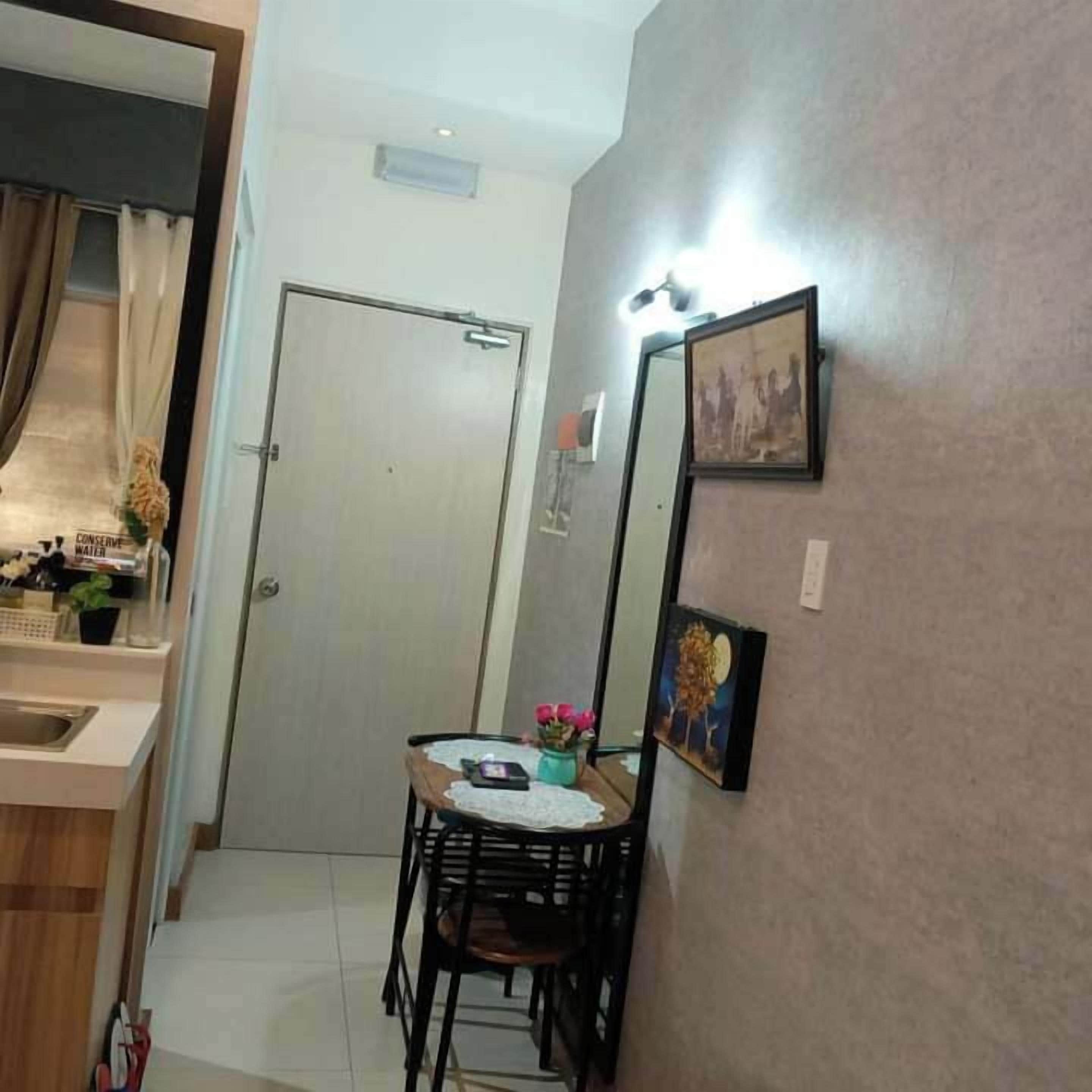 Cocina compacta con comedor, una puerta y un espejo instalado en la pared.