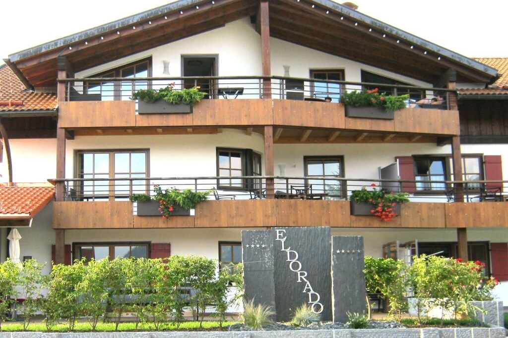 Un hotel de varios pisos con balcones, fachada de piedra y un cartel que dice 'ELDORADO'.