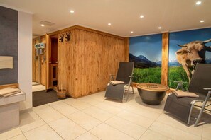 Habitació amb paret de fusta, sauna i un mural gran de vaca.