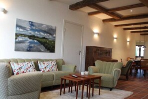 A living room with a green sofa, a wooden coffee table, and a painting of a landscape. - Holiday home with 5 bedrooms (Osterholz-Scharmbeck)