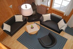 A cozy room with two sofas, a table, and a fireplace. - Swedish house in a holiday paradise (Krakow am See)