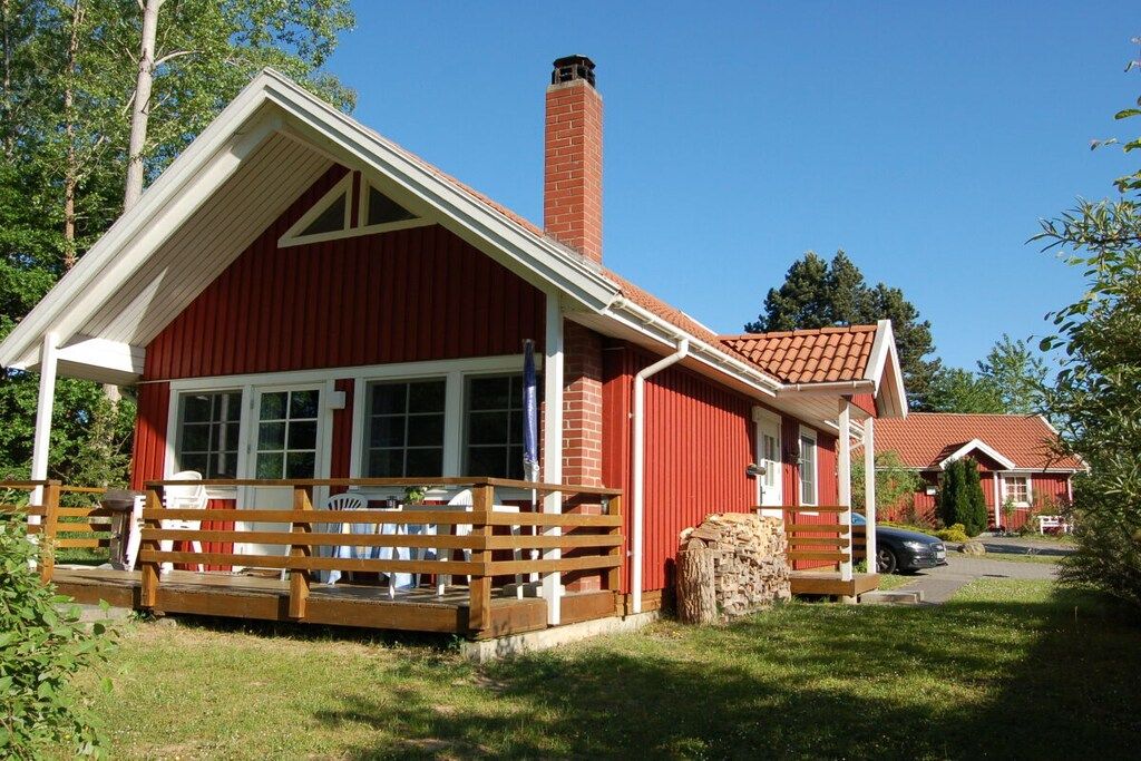Un edificio rojo con un porche blanco y una chimenea.