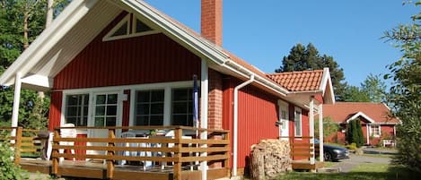 Un edificio rojo con un porche blanco y una chimenea.