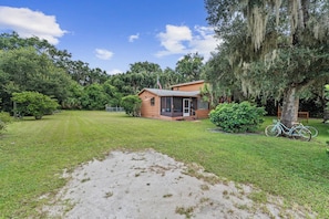 Unclassified image, 3 of 44, button - Escape to a quiet wooded retreat in New Smyrna Beach. This charming 2BR/1BA home features two queen bedrooms, an open kitchen and living area, dining for six, a screened front porch and covered back porch for relaxing and enjoying nature. (New Smyrna Beach)
