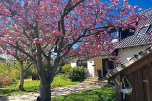 Il s’agit d’une propriété résidentielle dotée d’un jardin bien entretenu, d’un chemin menant à l’entrée et d’une maison avec un toit en tuiles.