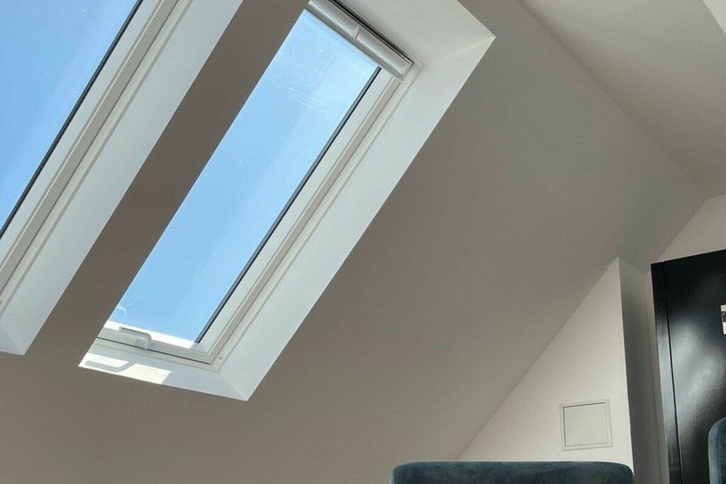 A skylight in a room with a dark-colored wardrobe and a white wall.
