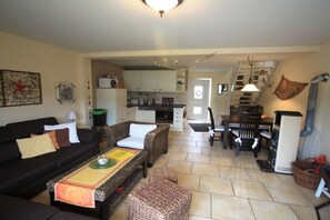 A living room with a sofa, a coffee table, and a dining area with a table and chairs. - Holiday home in Pruchten with barbecue (Pruchten)