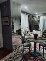 A dining area with a round table, chairs, and a patterned rug.