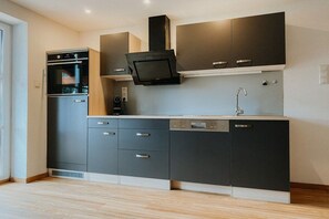 A modern kitchen with built-in appliances, a dishwasher, and a microwave. - Holiday apartment with 1 bedroom (Schönau am Königssee)