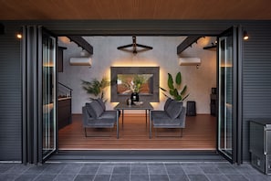 An open-plan living space with a dining area, two grey sofas, a table, and a large framed picture.