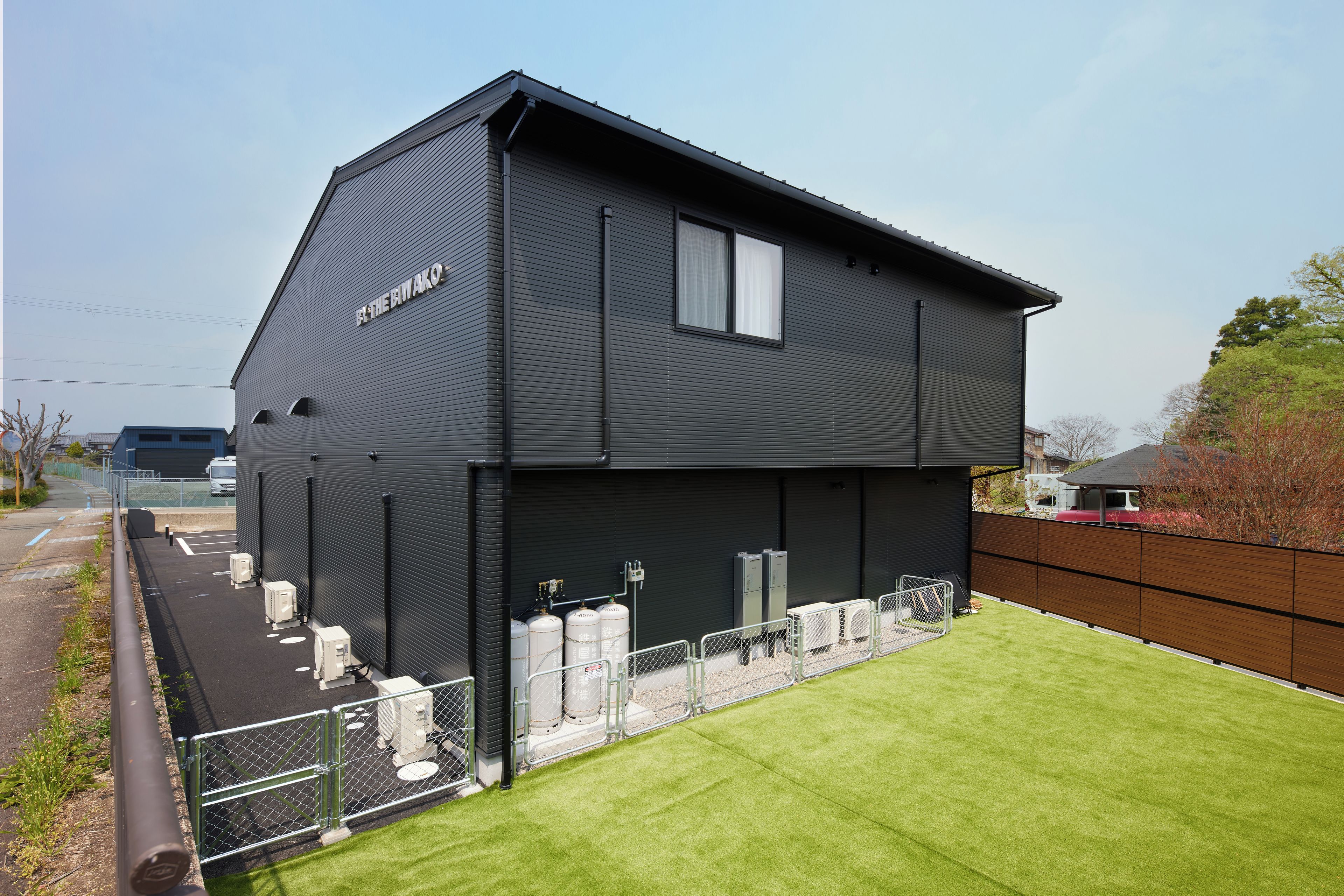 A modern two-story building with a flat roof and a sign that reads 'THE BIWAKO'.